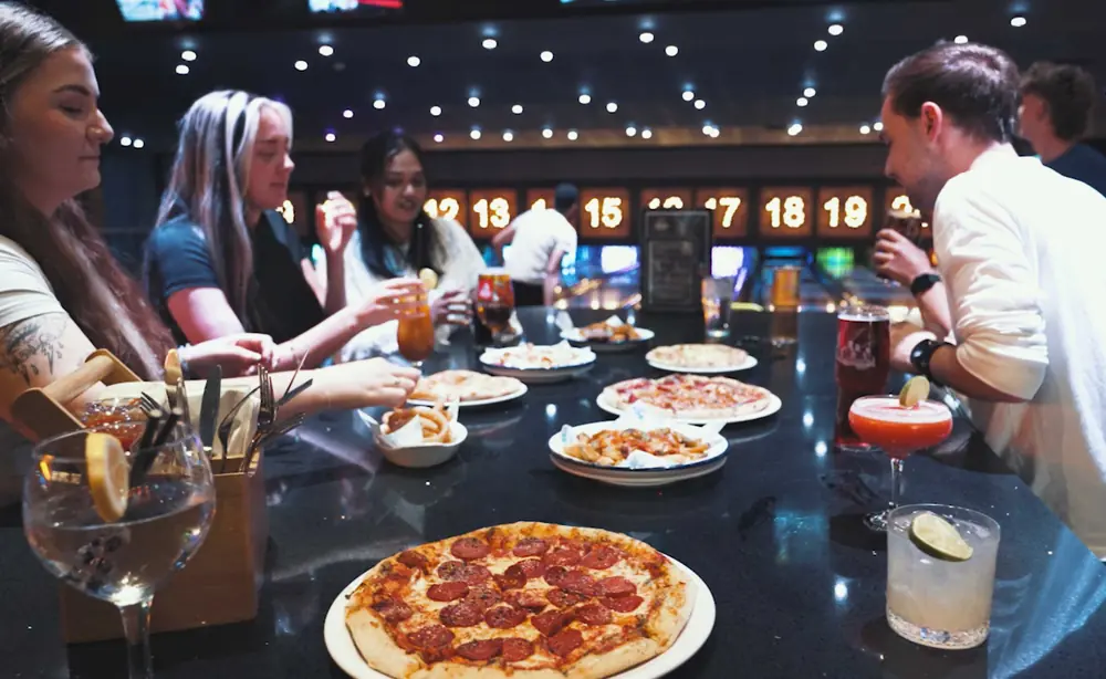 A spread of street food on a bowling lane table